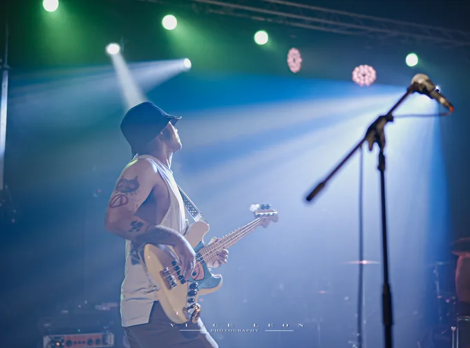 Bassist performing under bright stage lights