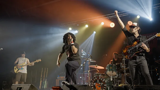 Full band with the guitarist raising a fist
